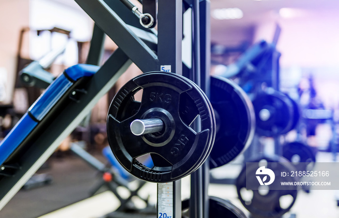 Fitness exercise equipment barbells in the sports gym. Black barbell plates in sport fittness center. Close-up