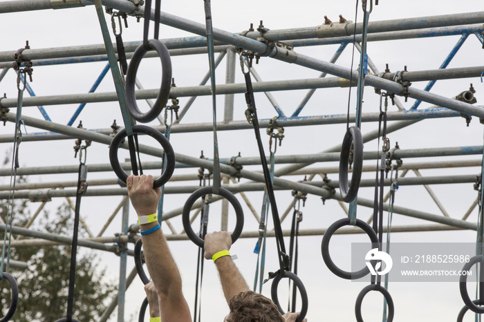 A person on hanging rings during an adventure obstacle course race