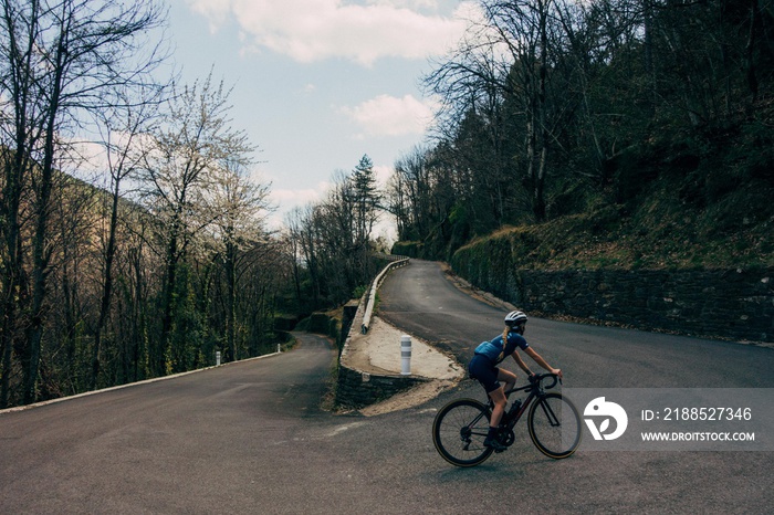 Cyclist climbing corner on mountain road