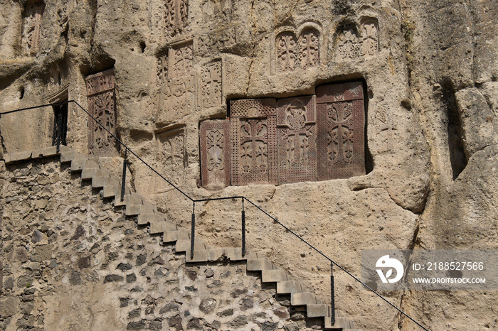 Intricately carved stone khatchkars are embedded in rock at Geghard Monastery (Monastery of the Spear), Garni, Armenia.