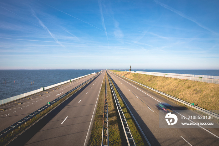 Motorway A7 on Afsluitdijk, a dam separating the North Sea from the Ijsselmeer lake. View from bridge at Breezanddijk, an artificial island.