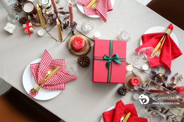 Festive table setting with Christmas decor and gift box in room