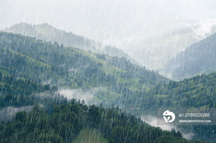 Rain over forest mountains. Misty mountain hills landscape on a rainy day.