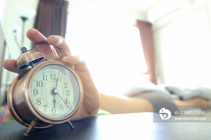 man sleeping in bedroom on vacation He turned off the alarm in the morning when he still didn’t want to wake up. health concept