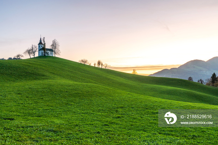 Sveti Tomaz, Slovenia - View of the church of Sveti Tomaz (St. Thomas) at sunset in the Skofja Loka area with clear golden and blue skies. Autumn time in the Slovenian Alps