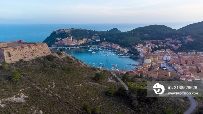 Top view of the small town of Porto Ercole, Tuscany Italy at sunset. Harbor with boats, fishing boats, emerald coast and city