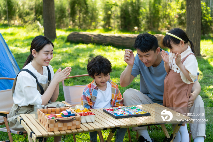 一家四口在露营地玩游戏开心欢呼庆祝