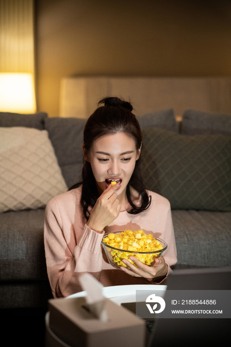 年轻女士在家吃使用电脑