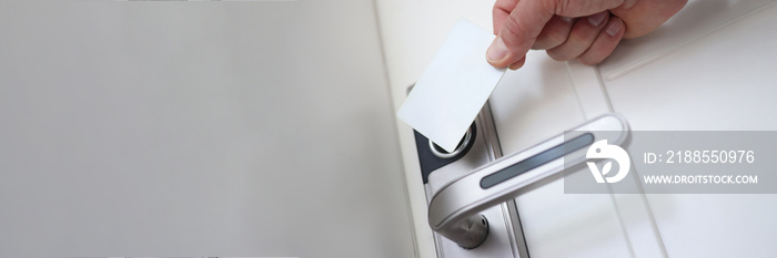 Man applying plastic card to door lock to open closeup