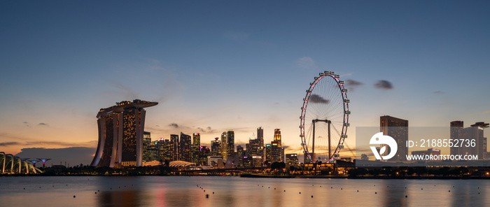 Wide panorama image of Singapore skyscrapers at dusk.