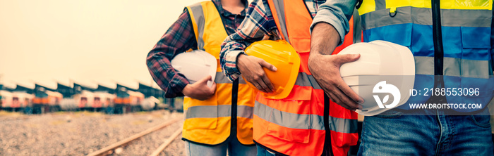 Team engineer holding helmet standing in row on site work at train garage, banner cover design.