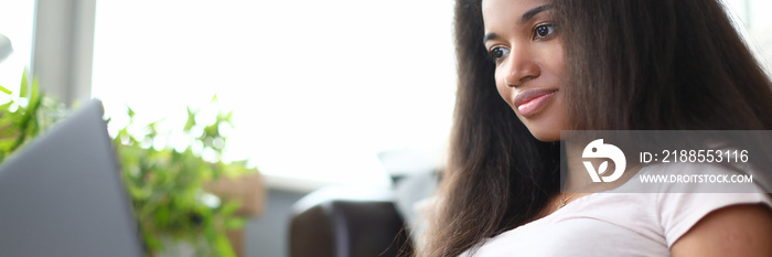 Black woman work remotely on laptop from home. Modern and professional worker via Internet.