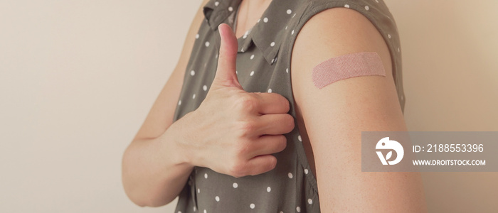 woman showing thumb up and her arm with bandage after got vaccinated or  inoculation, delta variant vaccine