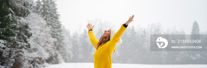 Young woman celebrating life standing in winter nature