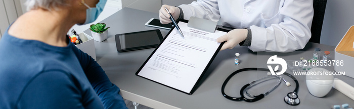 Female doctor explaining to her patient the consent form to coronavirus vaccine