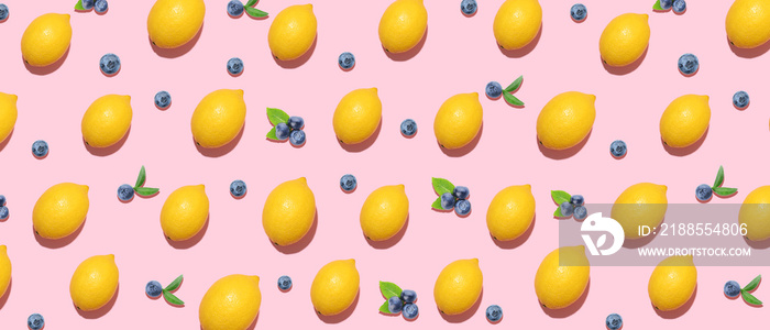 Many ripe lemons and bilberries on pink background. Pattern for design