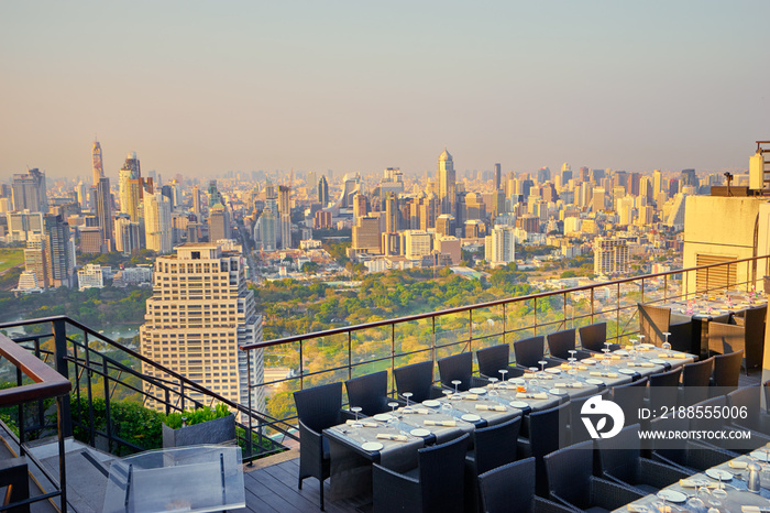 Table setting on roof top restaurant with megapolis view, Bangkok Thailand.