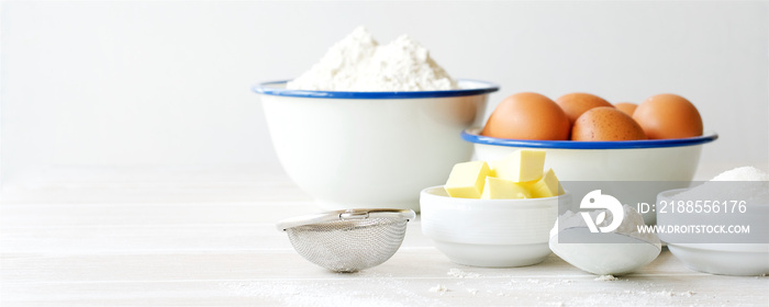 Ingredients for making dough, dessert on white wooden table. Flour, butter, sugar, eggs ingredients