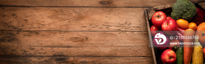 wooden background with fresh juicy vegetables and fruits in a copyspace box on an empty wooden table, panoramic photo.