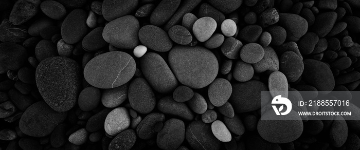 Dark black abstract smooth round pebbles sea texture background