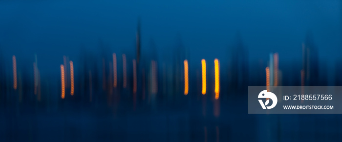 Motion Blurr of industry background with defocused cargo dock terminal in sea with colorful bokeh lights at midnight. Urban and industry backdrop