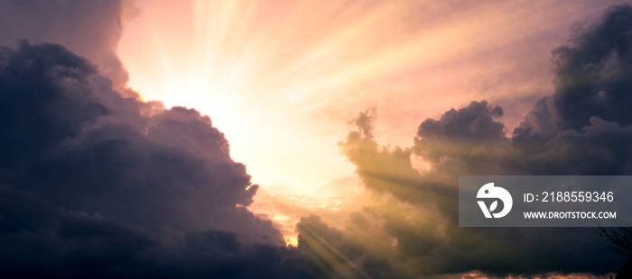 Cloudscape image of dark stormy clouds in blue sky with sun beam. The rays of the sun after the rain. Scenery with the sun’s rays filtering through the gray clouds. Dramatic sky as the sun hides