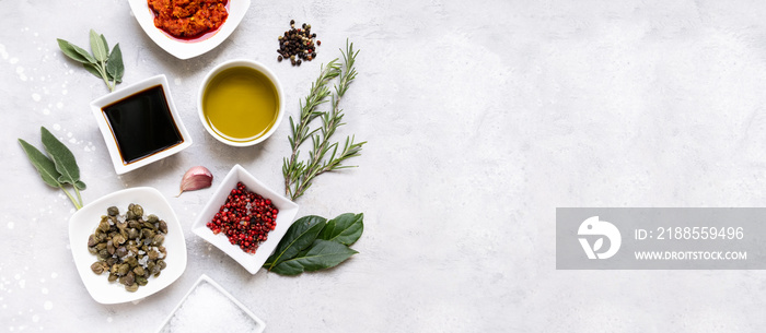 Set of spices and sauces for cooking food  olive oil, soy sauce, harissa, capers, pink pepper coarse salt rosemary sage garlic