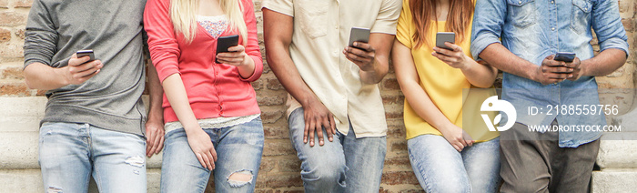 Diverse culture students watching smart mobile phones in university break