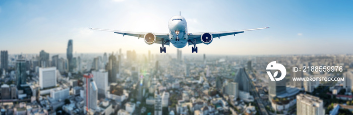 Panoramic view over the evening city, and white passenger plane flying in the day blue sky above a city