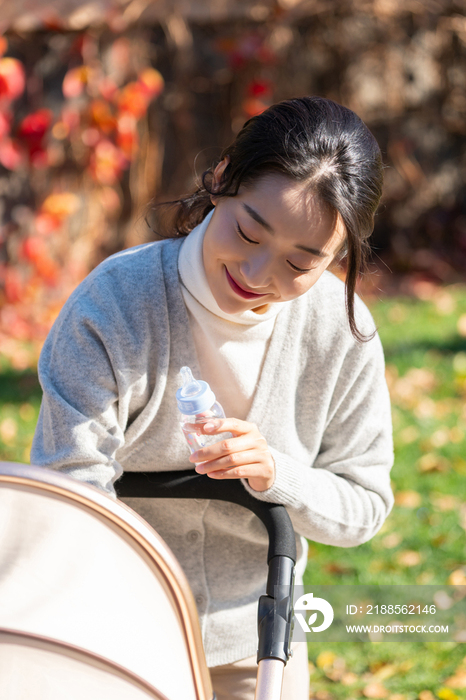 年轻的母亲推着婴儿车散步