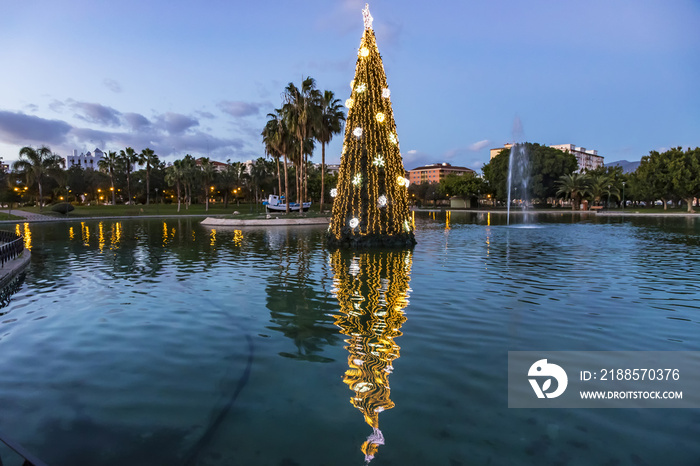 Illuminated decorated New Year tree reflected in the water