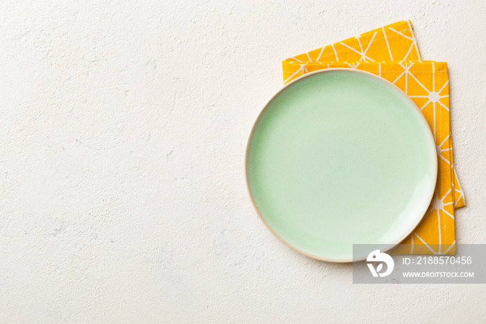 Top view on colored background empty round green plate on tablecloth for food. Empty dish on napkin 