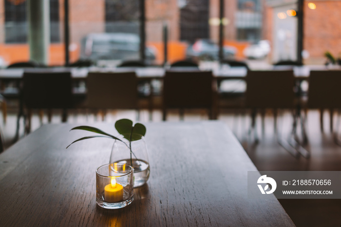 Table setup in a indoor restaurant with dish flowers and lights