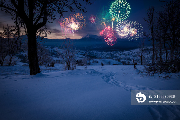 New Years firework display in winter alpine mountain landscape.