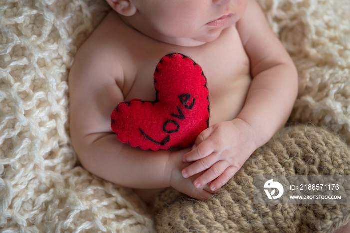 Baby Holding a Heart Shaped Pillow
