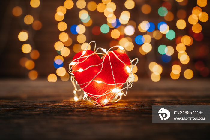 Red heart shape covered led lights on wooden and bokeh lights background. Valentines day and romance