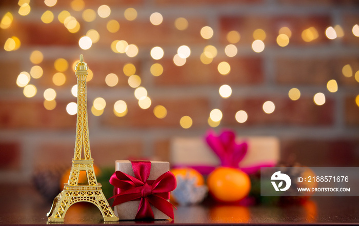 golden eiffel tower souvenir on background with fairy lights in bokeh. Christmas Holiday season