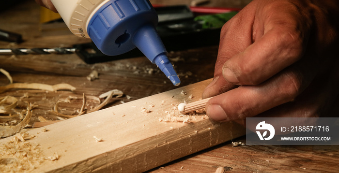 Handyman assembling wooden pieces with a glue