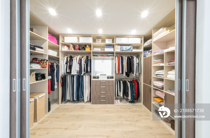 Big wardrobe with different clothes for dressing room