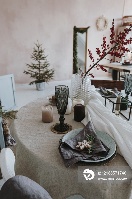 Elegant aesthetic Christmas dinner serving concept. Bright living room interior with table, beige li