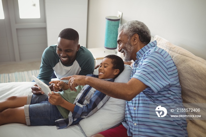 Multi-generation family using digital tablet on bed