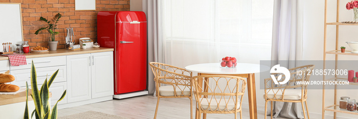 Interior of modern kitchen with stylish red refrigerator