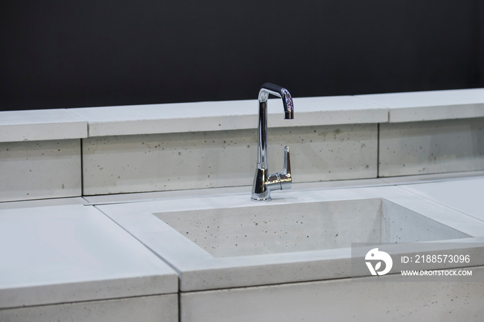 Modern kitchen, the water tap and concrete kitchen sink.  Concrete kitchen with a tap and gray workt