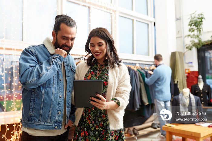 couple with tablet pc at vintage clothing store