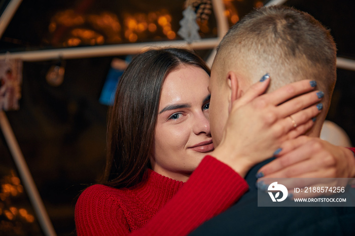 Young couple in love hug each other on the black background