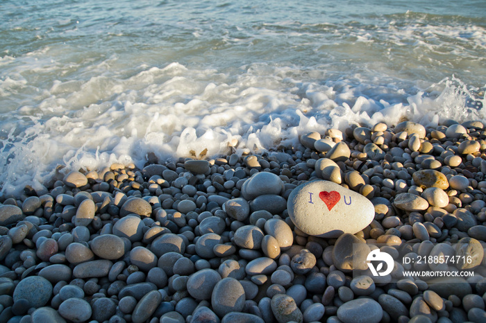 I love you and heart painted with a red paint marker on the pebble as a gift for Saint Valentines d