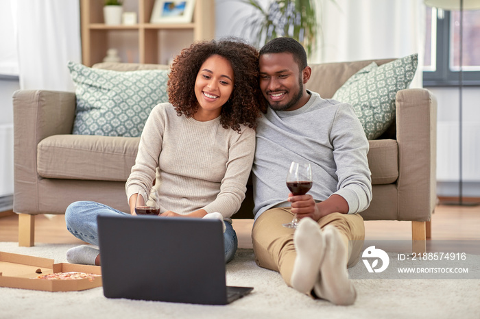 leisure, people and technology concept - happy african american couple with laptop computer and take
