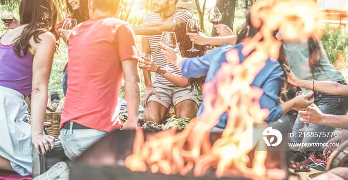 Happy friends having picnic dinner with barbecue in nature outdoor