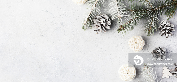 Christmas background with a gifts, fir tree branches, cones and snow on gray concrete table. Christm