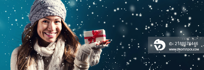 Happy young woman holding a Christmas present